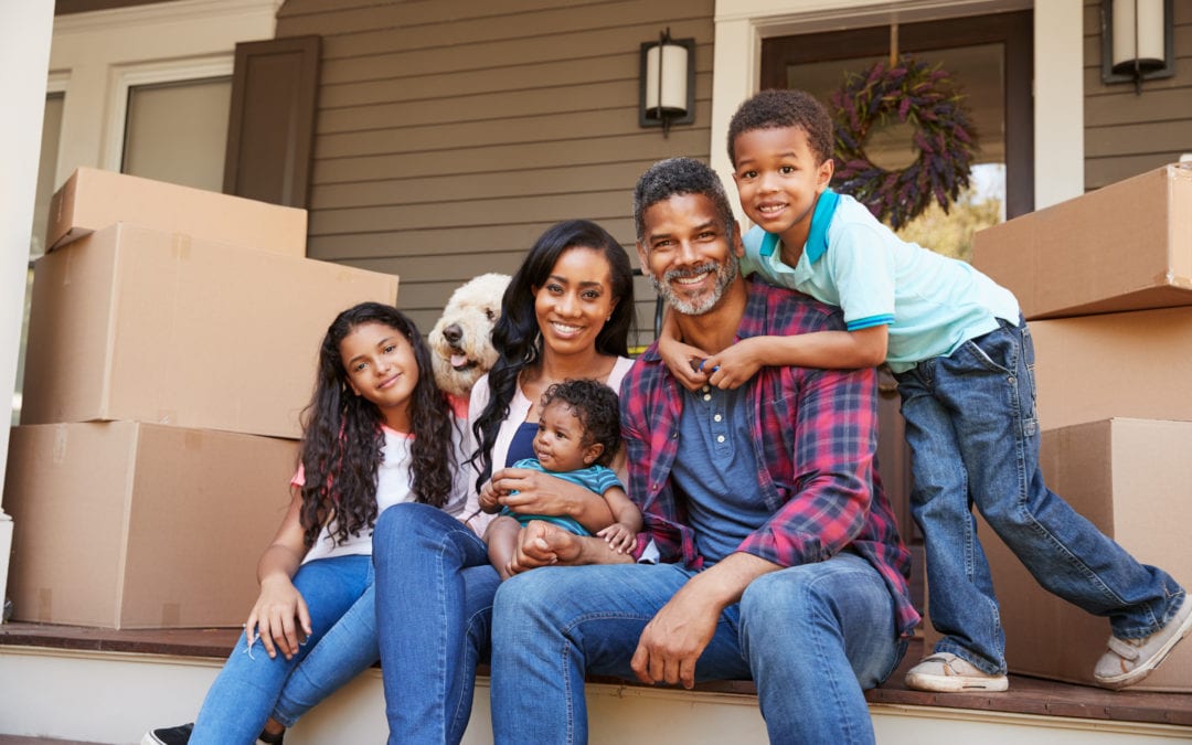 Family With Children And Pet Dog Outside House On Moving Day