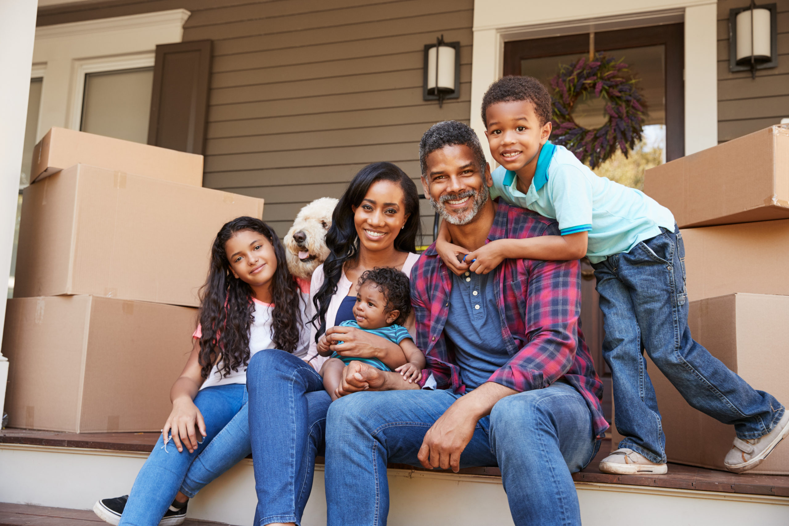 Family With Children And Pet Dog Outside House On Moving Day