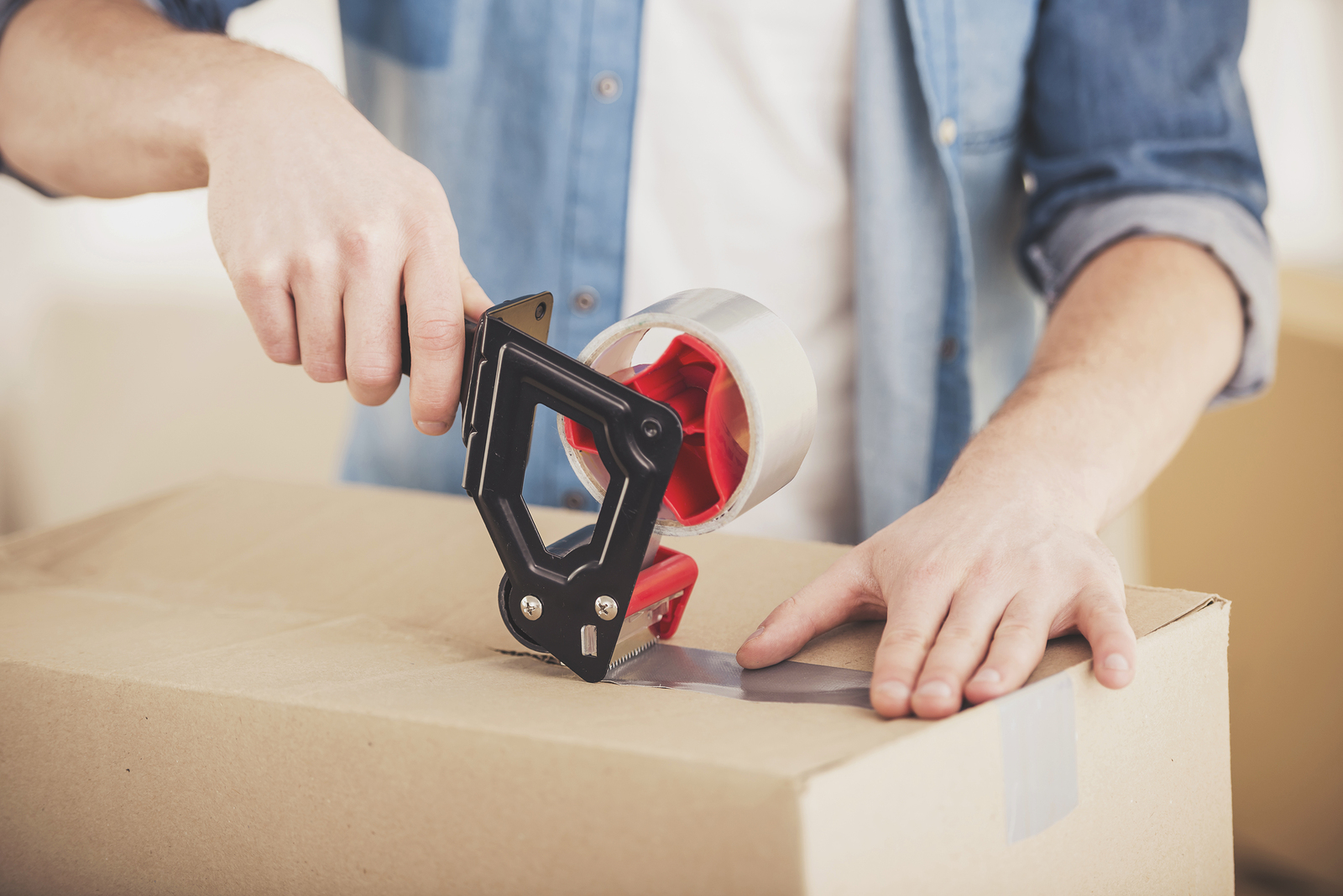 bigstock-Young-Man-Packing-Box-Moving-250935988-1